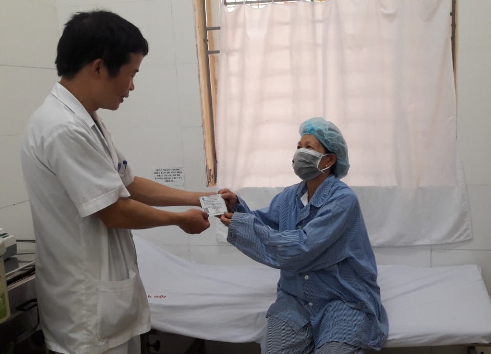 Đại diện Tổ Công tác xã hội đang trao tấm thẻ BHYT cho người bệnh nghèo tại Bệnh viện Phổi Hà Nội